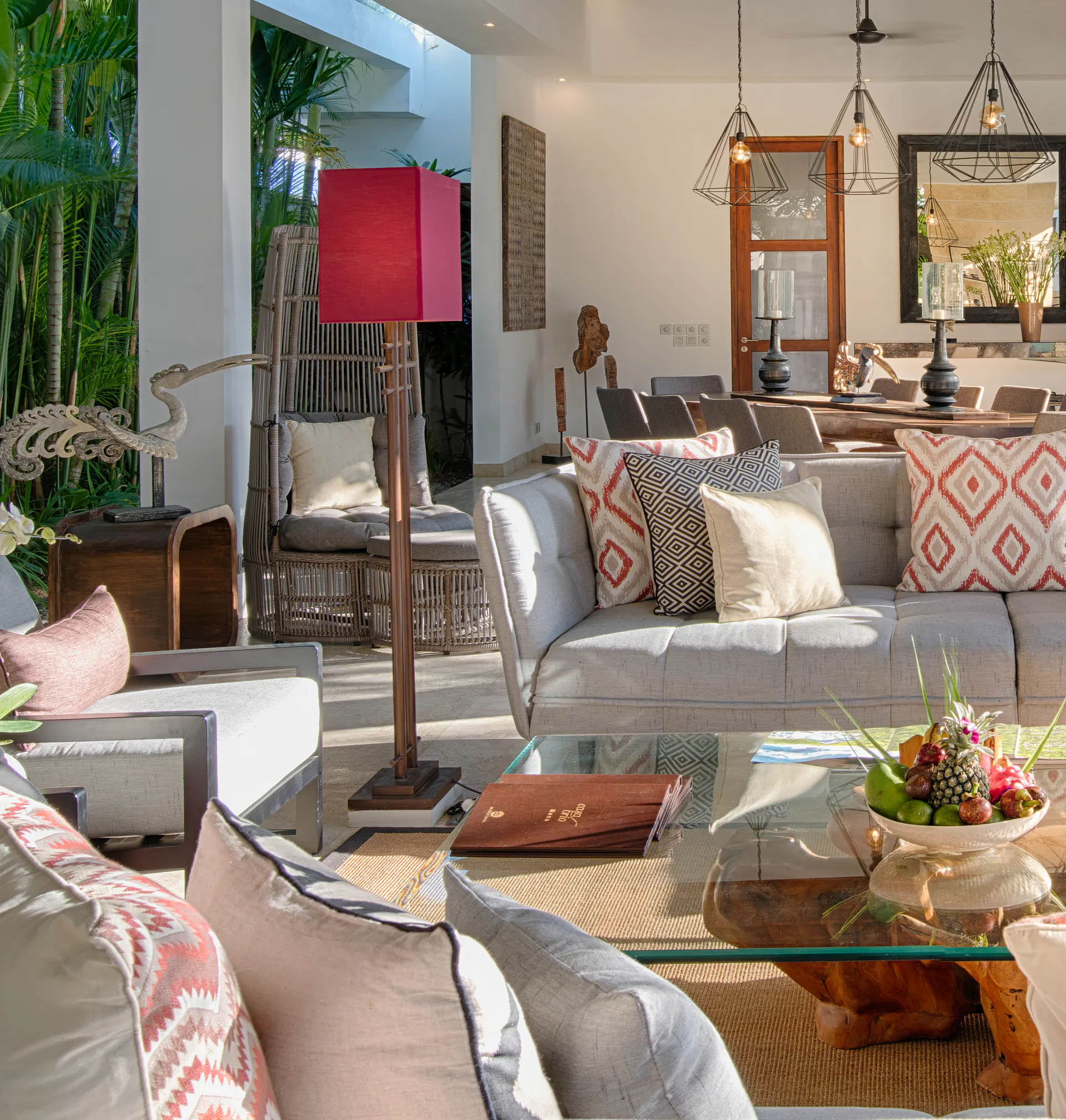 Cushions in coral, cream and grey on the pavilion sofas at Casa Brio, with orchids on the glass table