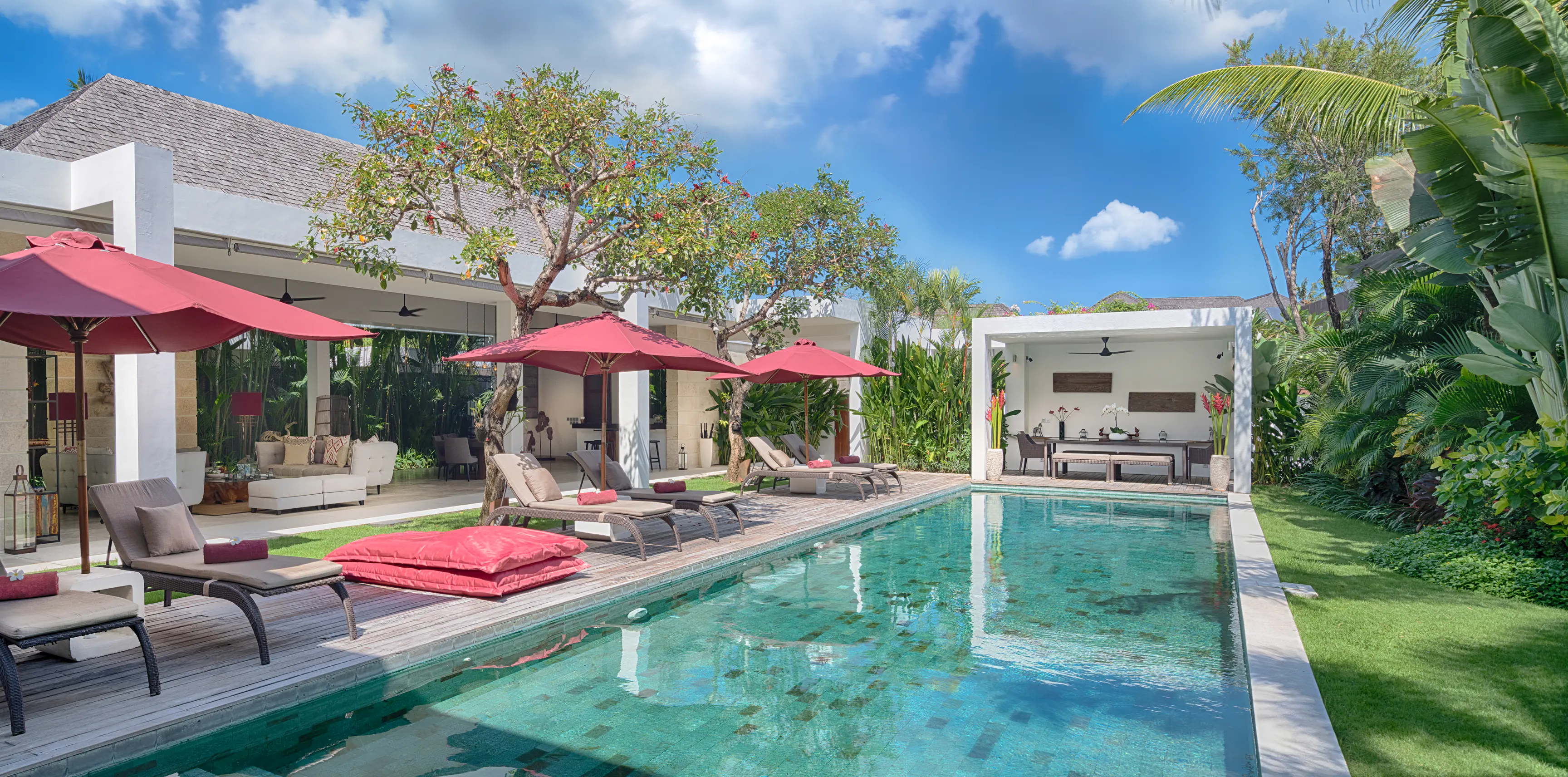 The 21-metre pool at Casa Brio along the ironwood deck, claret parasols and loungers on one side and the open living pavilion on the other